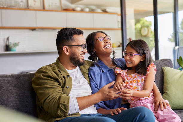 Família sorrindo no sofá de casa